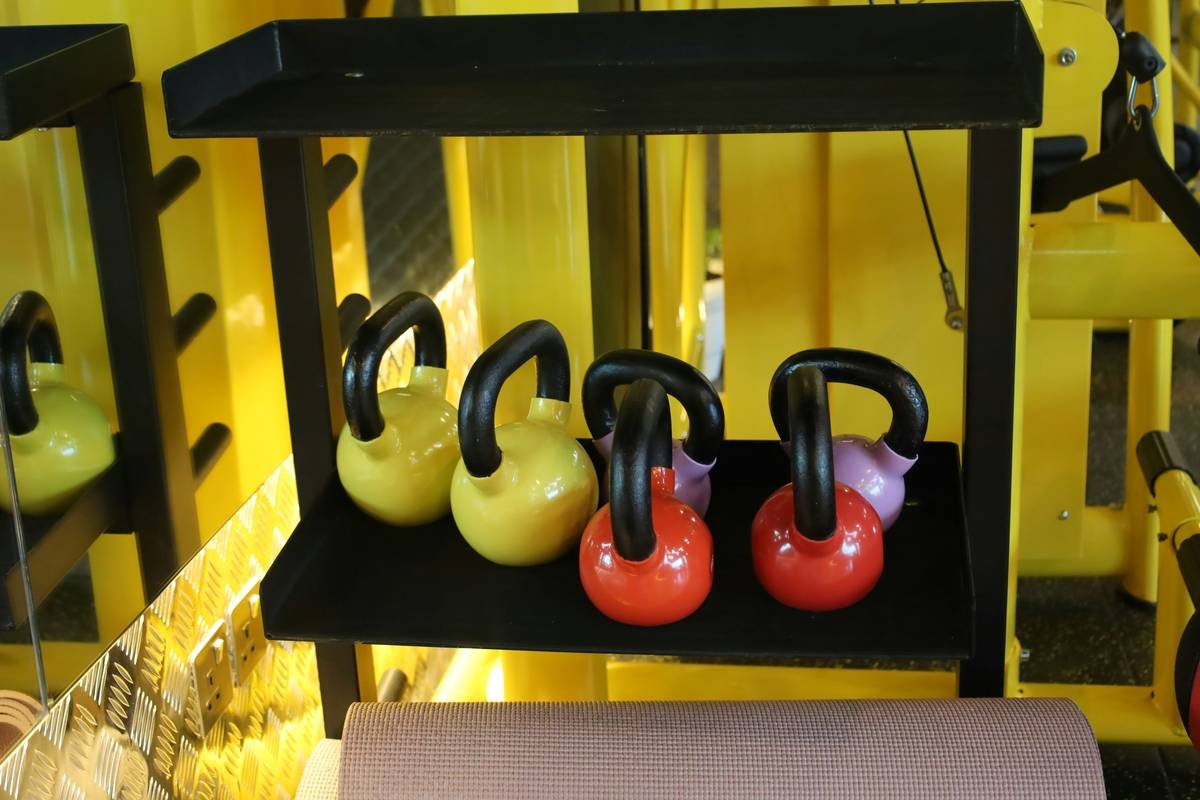 A woman performing a kettlebell swing at the gym.
