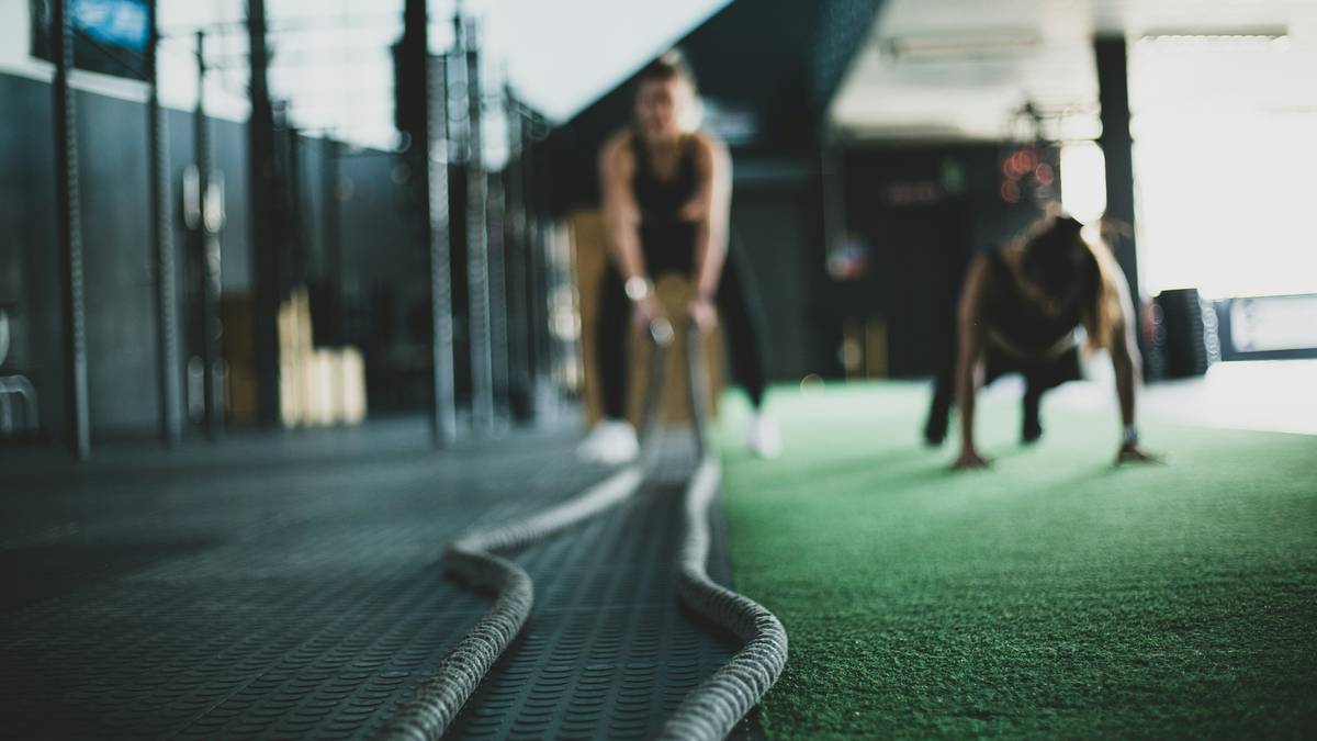 A woman swinging a kettlebell in a gym setting