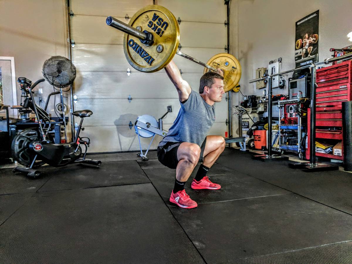 Smiling woman holding a kettlebell after a workout.