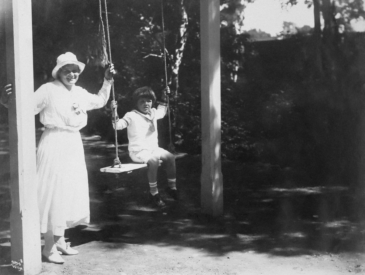 A woman performing a kettlebell swing in a gym setting