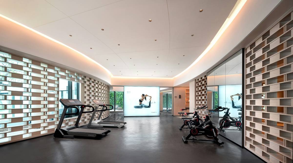 Woman performing a kettlebell swing outdoors in a park